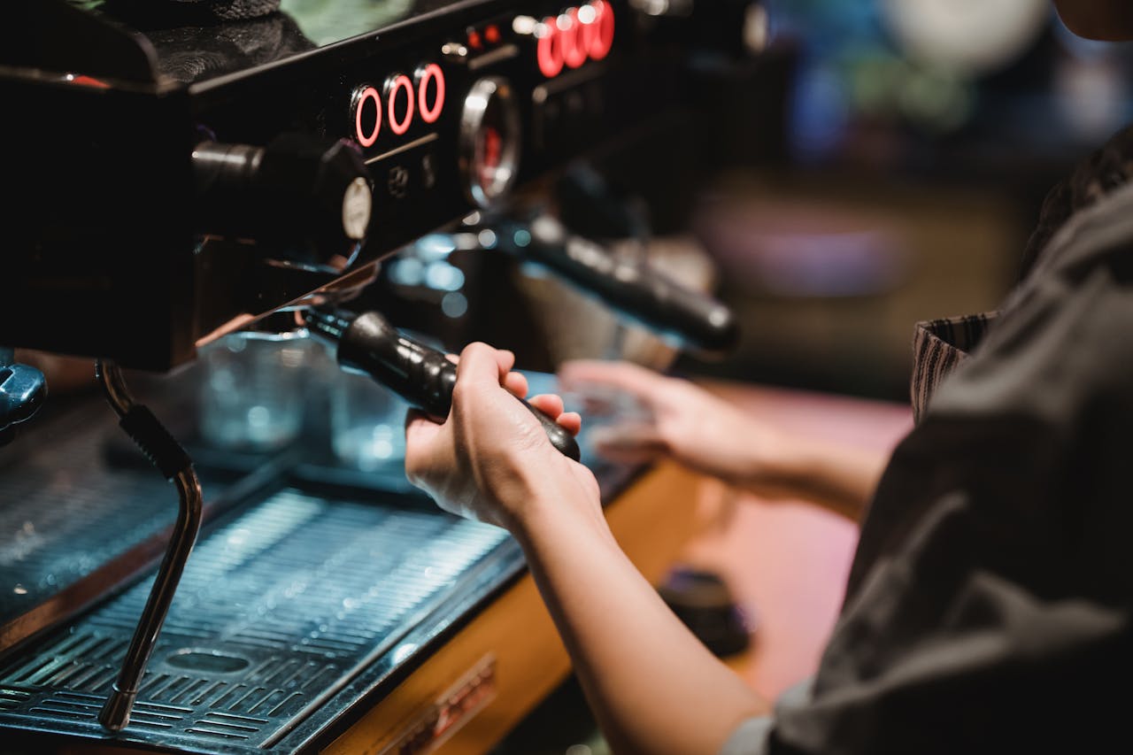 A barista skillfully operating an espresso machine in a cozy coffee shop setting.